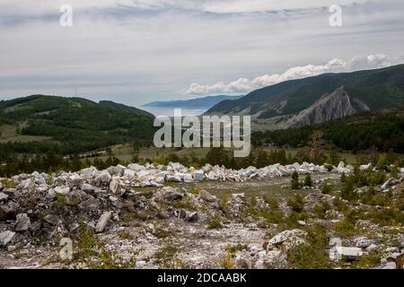 View from the old marble quarry to the village of Buguldeyka near Lake Baikal. A small village between the hills. A ridge of white marble.. Stock Photo