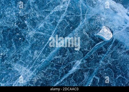 Amazing ice structure with cracks and air bubbles. Little melted ice floe on blue ice. Winter pattern. Horizontal. Stock Photo