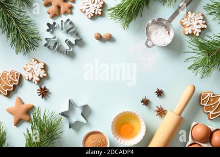 Christmas gingerbread cookies with ingredients for cooking in light blue background. Merry Christmas and Happy New Year. Copy space Stock Photo