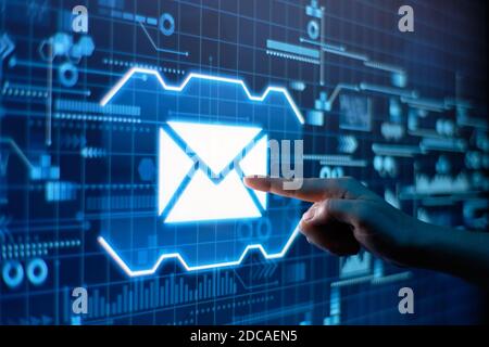 A hand presses email on a futuristic display. Stock Photo
