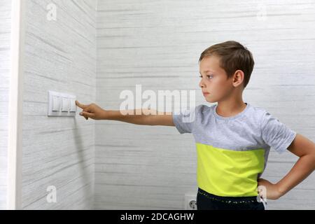 Child turns off the light at home Stock Photo