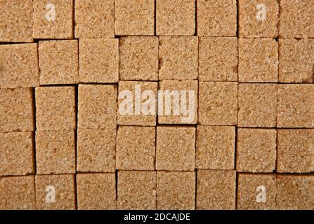 Close up background texture pattern of brown cane sugar cubes arranged Stock Photo