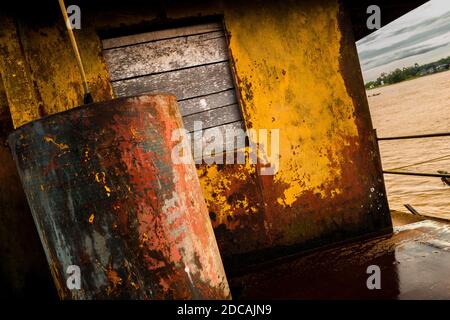 A boarded up window is seen on the deck of an old gold dredge anchored in the Atrato river in Quibdó, Colombia. Stock Photo