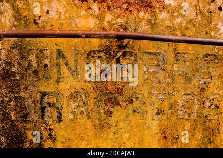 Embossed letters are seen on a rusty side wall of an old gold dredge anchored in the Atrato river in Quibdó, Colombia. Stock Photo