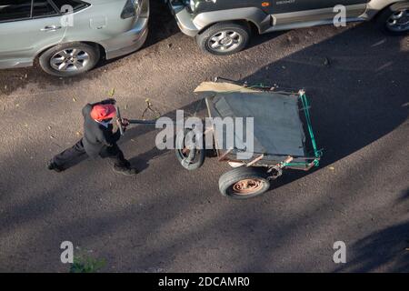"Tchova", local term for human-powered wheelbarrow in Mozambique, being pushed down the street Stock Photo