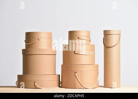 Set of kraft cardboard gift boxes of a round shape on a gray background Stock Photo