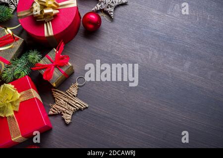 Christmas decoration and gift boxes on dark wooden table. Christmas or New Year holiday background shows the magic of Christmas holiday. Top view. Stock Photo