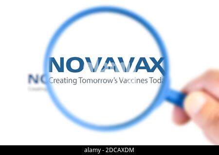 Benon, France - November 20, 2020:Novavax research laboratory logotype enlarged with a magnifying glass.This laboratory has developed a vaccine agains Stock Photo