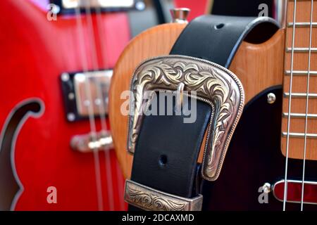 Electric guitars and leather strap with silver buckle close-up. Stock Photo