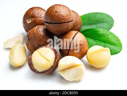 Macadamia nuts with peeled macadamia and leaves isolated on a white background. Stock Photo