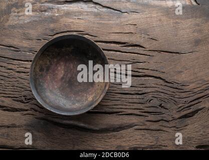 Empty old wooden plate on cracked old wooden table. Top view. Stock Photo