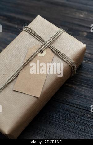 Christmas gift box wrapped in craft paper over wooden table prepared for celebrating festive holiday season Stock Photo