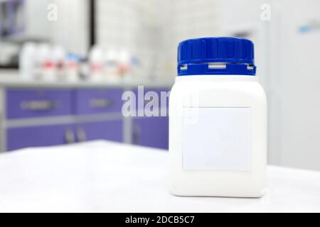 Unlabeled plastic chemical bottle container with cap in a white chemistry laboratory with copy space. Stock Photo