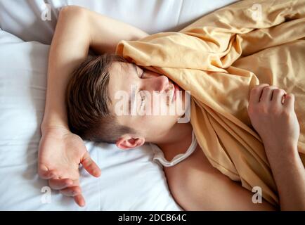 Tired Young Man sleep in the Bed at the Home closeup Stock Photo