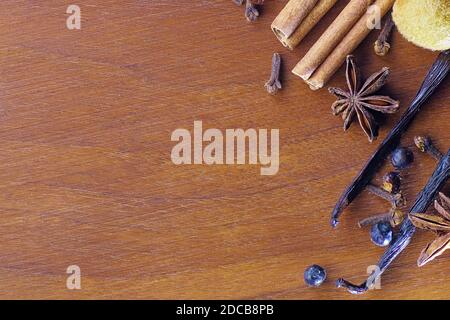 Walnut wooden board laden with Christmas spices, cinnamon, star anise, bourbon vanilla beans, cloves, juniper berries. Food, spices and Christmas conc Stock Photo