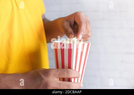 close up of young man in casual dress eating popcorn  Stock Photo