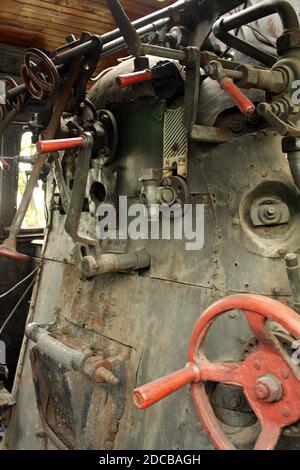 Antique locomotive, vintage steam engine. Inside of drivers cab, drivers control panel and closed furnace door. Stock Photo