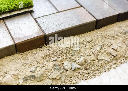 industrial worker installing pavement rocks, cobblestone blocks on road pavement Stock Photo