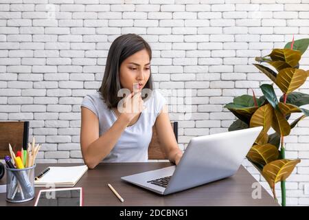 Portrait of Asian woman freelancer working at home, sitting at desk dining table in living room Stock Photo