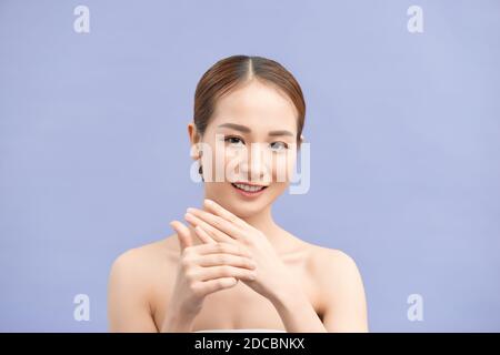 Young beautiful woman applying hands cream Stock Photo