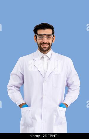 Portrait of confident male Middle Eastern Arab researcher scientist medical doctor wearing  protection glasses standing and put hands in pockets isola Stock Photo