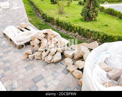 industrial worker installing pavement rocks, cobblestone blocks on road pavement Stock Photo