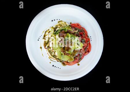 Vegetable salad with tomato cheese, on a white plate, isolate. Stock Photo