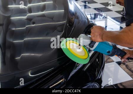 Man working for polishing, coating cars. polishing of the car will help eliminate contaminants on the surface of the car. Stock Photo