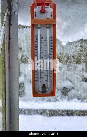 Winter and a Max and Min thermometer hanging inside an unheated greenhouse in smallholding garden at 900ft Stock Photo