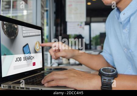 man using a computer to search for jobs.Social networking technology in searching for information Stock Photo