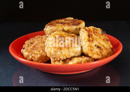 The Roasted chop in red plate on black background. Products of the meat feeding Stock Photo