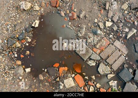 Very bad road conditions, a road surface consisting of rubble and mud Stock Photo