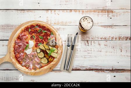 Top view of pizza on wooden cutting boards with cutlery and beer Stock Photo