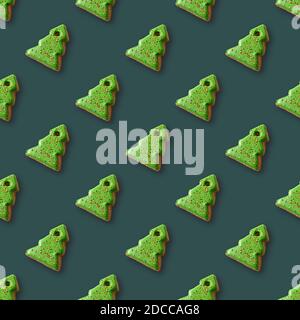 Seamless pattern of gingerbread in shape decorative Christmas tree on green background. Xmas holiday abstract background. Stock Photo