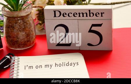 Christmas message written on notepad with white cube and red background. Merry Christmas Concept Stock Photo