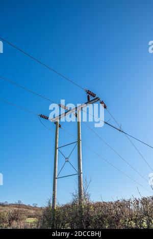 Wooden telegraph pole with wires and insulators with a clear blue sky background Stock Photo