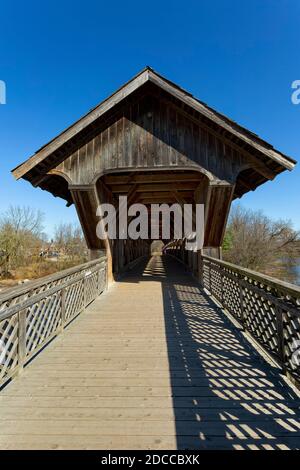 The all wood lattice covered pedestrian & cyclist covered bridge over the Eramosa River built in 1992. Guelph Ontario Canada Stock Photo