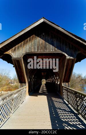 The all wood lattice covered pedestrian & cyclist covered bridge over the Eramosa River built in 1992. Guelph Ontario Canada Stock Photo