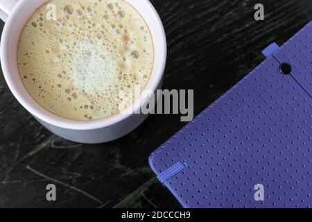 Cup of coffee and agenda on the table Stock Photo