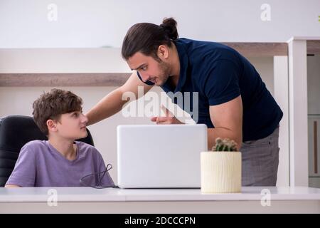 Father and schoolboy playing computer games at home Stock Photo