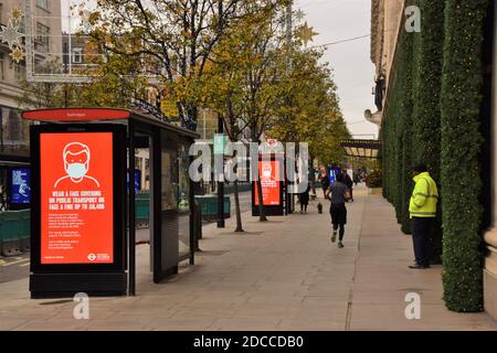 Wear A Face Covering signs on bus stops outside Selfridges on Oxford Street during the second national lockdown in England. Stock Photo