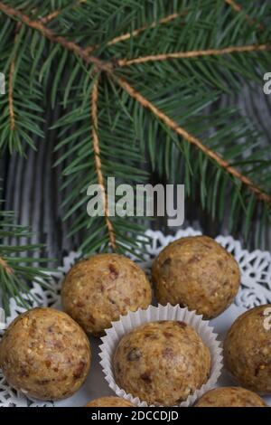 Dried fruit and oatmeal sweets. On black pine boards. Nearby there are fir branches. Close-up shot. Stock Photo