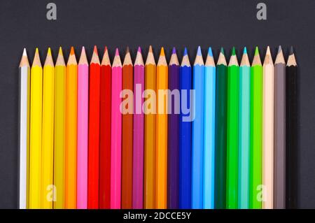 Line of colored pencils on black background Stock Photo