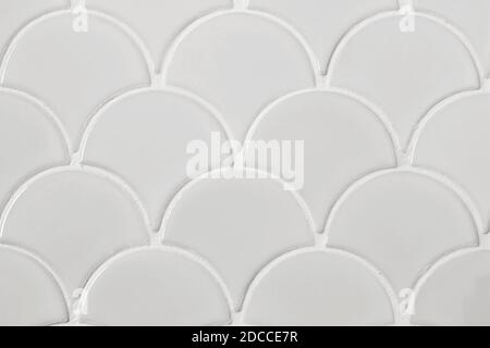 Light gray ceramic tiles in the form of scales. Mosaic Tiles on the wall Stock Photo