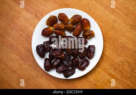 Premium Dates on a white plate. Fresh good date isolated Stock Photo
