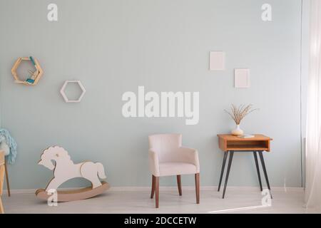 Minimalistic nursery room with side cabinet, toys and wooden horse Stock Photo