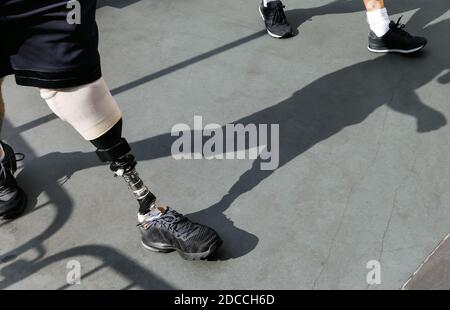 Modern leg prosthesis. Disabled young man with foot prosthesis walks along the street. Stock Photo