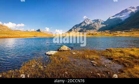 Sun is setting at Lej Pitschen, together with Lej Nair and Lago Bianco one of three lakes at The Bernina Pass. Stock Photo