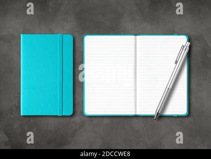 Aqua blue closed and open lined notebooks with a pen. Mockup isolated on dark concrete background Stock Photo