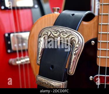 Electric guitars and leather strap with silver buckle close-up. Stock Photo